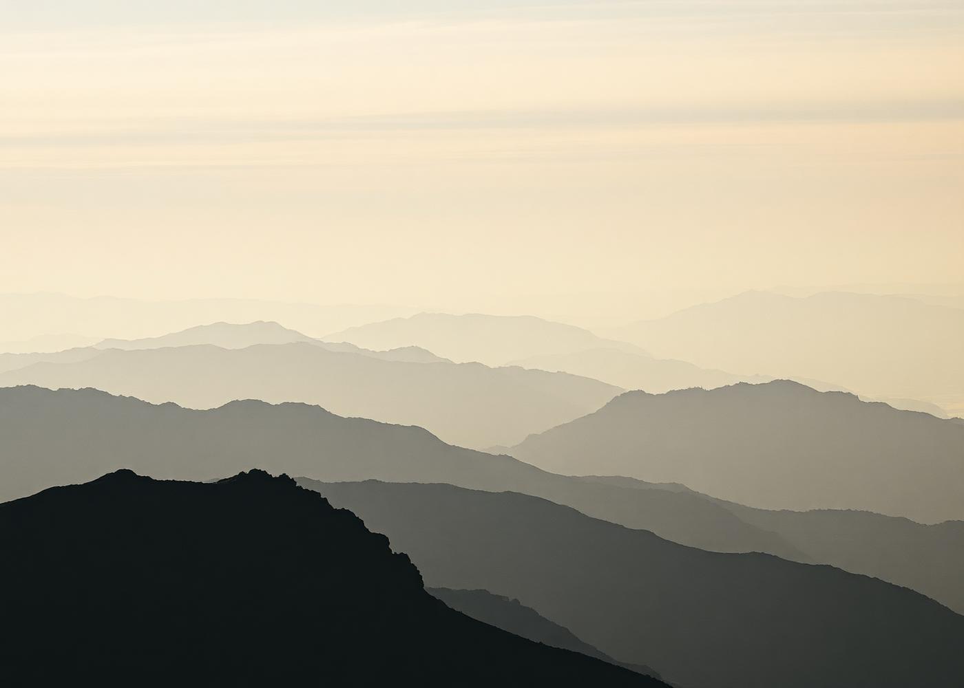 Layered alpine ridgelines fading into morning mist.